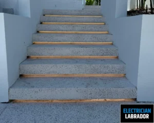 Concrete stairs with wooden steps leading to a doorway.