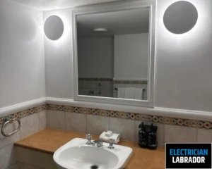 Modern bathroom with a white sink, mirror, and tile accents.